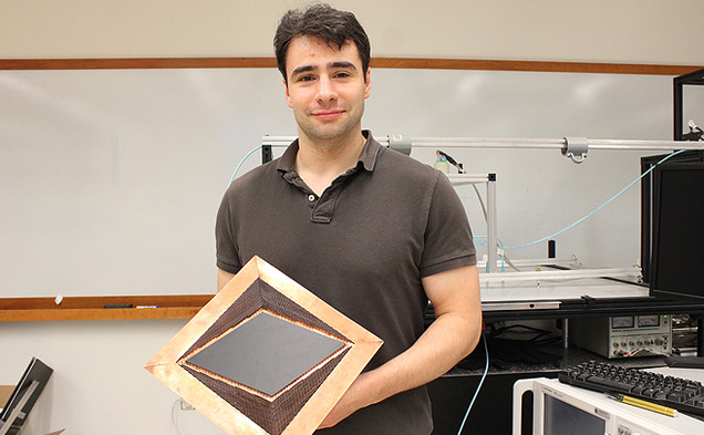 Graduate student Nathan Landy holds an invisibility device, which he worked to develop with engineering professor David Smith.
